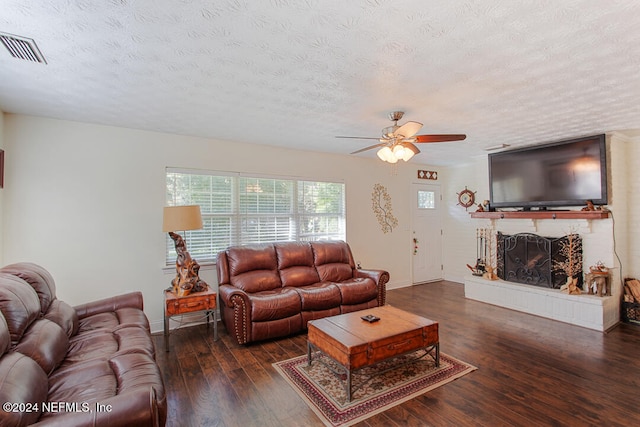 living room featuring dark hardwood / wood-style floors, a textured ceiling, and ceiling fan