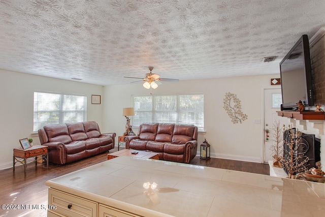 living room with dark hardwood / wood-style floors, a textured ceiling, and ceiling fan