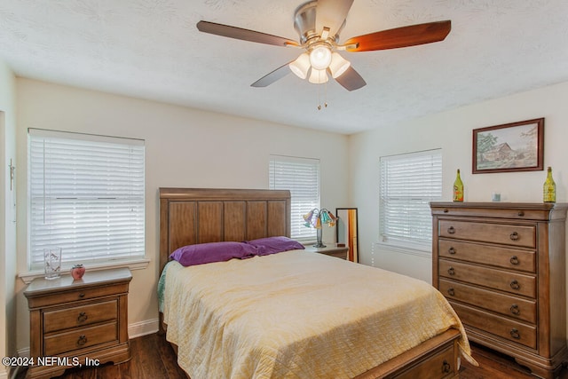 bedroom featuring dark wood-type flooring, ceiling fan, and a textured ceiling