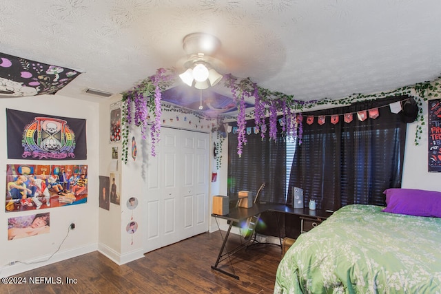 bedroom with ceiling fan, a textured ceiling, a closet, and dark hardwood / wood-style flooring