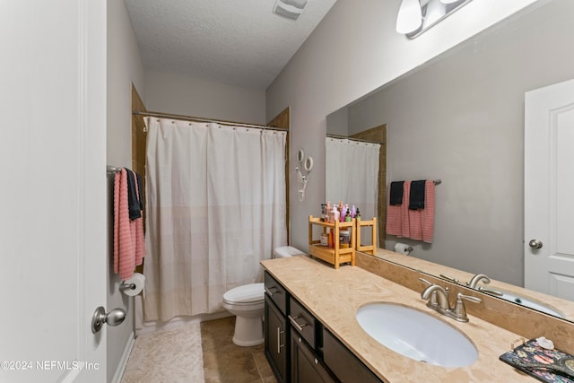 bathroom with vanity, tile patterned floors, a shower with shower curtain, toilet, and a textured ceiling