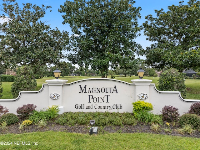 community / neighborhood sign featuring a lawn