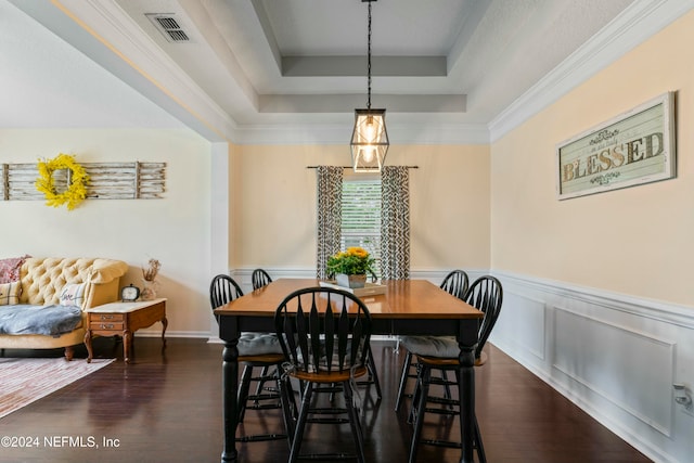 dining room featuring dark hardwood / wood-style floors, crown molding, and a tray ceiling