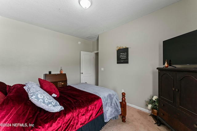 bedroom with light carpet and a textured ceiling