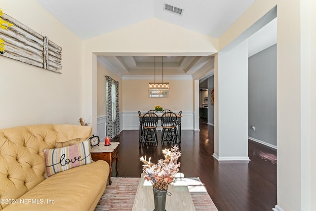 living room featuring a raised ceiling, dark hardwood / wood-style flooring, ornamental molding, and vaulted ceiling