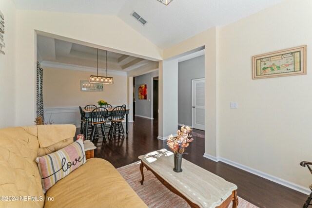 living room with lofted ceiling, dark wood-type flooring, and ornamental molding