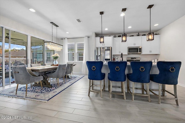 kitchen with a wealth of natural light, stainless steel appliances, and white cabinetry