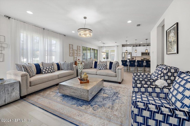 living room featuring a notable chandelier and light hardwood / wood-style floors