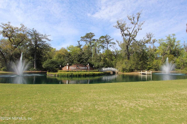 view of home's community featuring a lawn and a water view