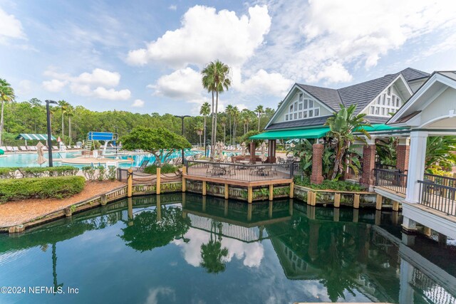 dock area with a water view and a community pool