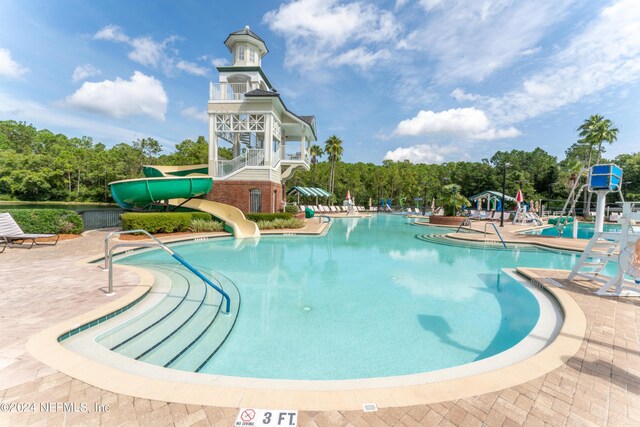 view of pool featuring a water slide and a patio area