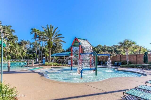 view of pool with pool water feature and a playground