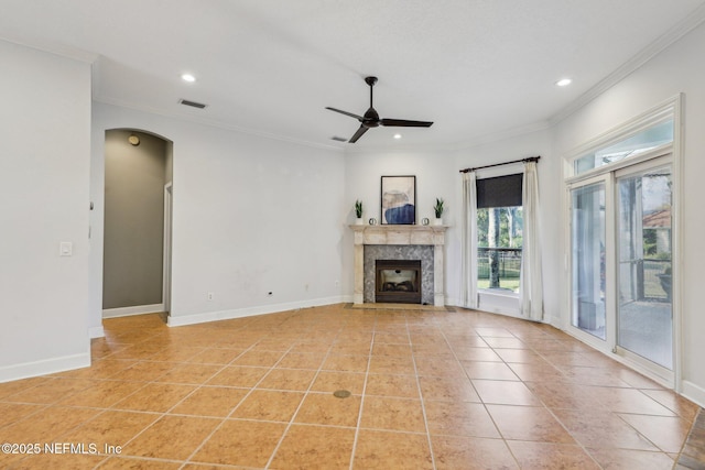 unfurnished living room featuring ceiling fan, ornamental molding, a high end fireplace, and light tile patterned floors