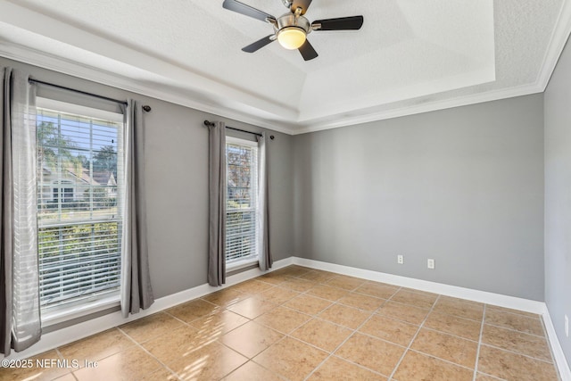 spare room featuring crown molding, ceiling fan, a textured ceiling, light tile patterned flooring, and a raised ceiling