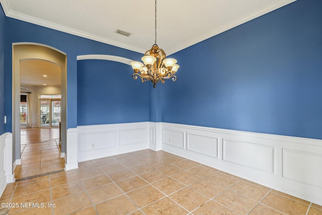 empty room featuring ornamental molding, tile patterned floors, and an inviting chandelier