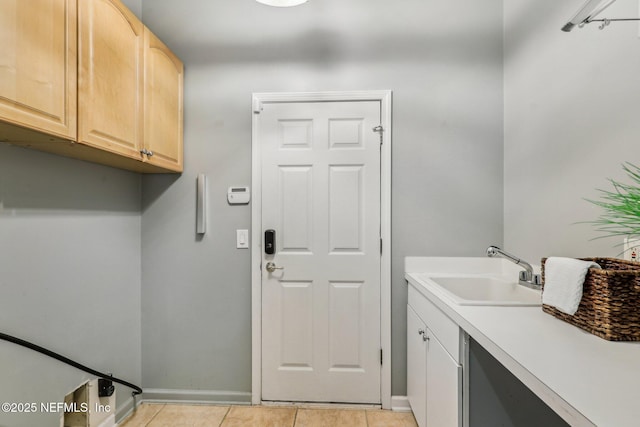 laundry room featuring cabinets, sink, and light tile patterned floors