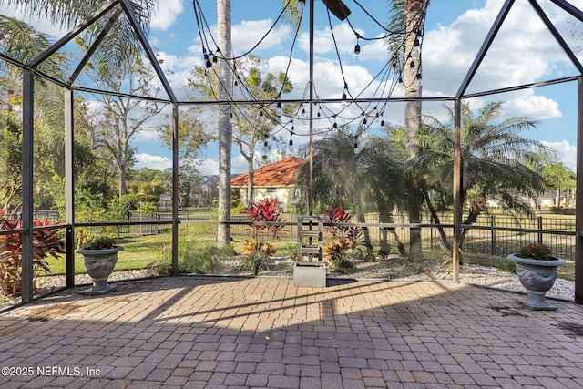 view of patio featuring glass enclosure