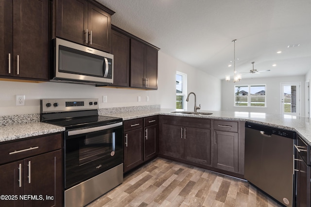3145 Forest View Ln, Green Cove Springs, FL 32043 - kitchen with stainless steel appliances, dark brown cabinetry, light wood-style flooring, light stone countertops, and recessed lighting