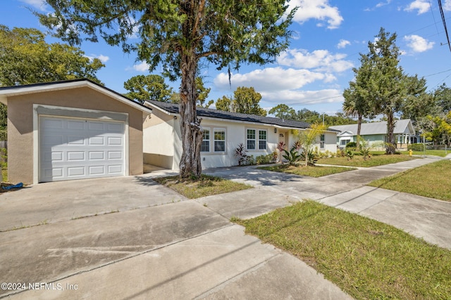 single story home featuring a garage and a front lawn