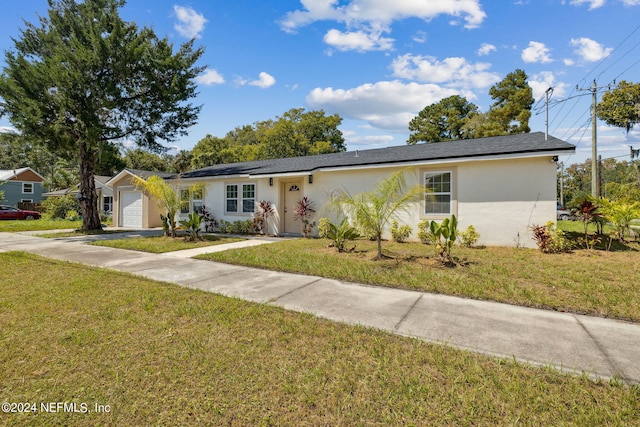 single story home featuring a garage and a front lawn