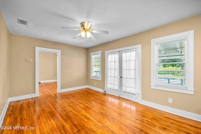 empty room with french doors, light hardwood / wood-style floors, and ceiling fan