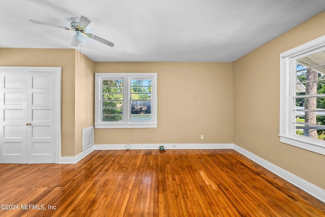 unfurnished room featuring hardwood / wood-style floors, a healthy amount of sunlight, and ceiling fan