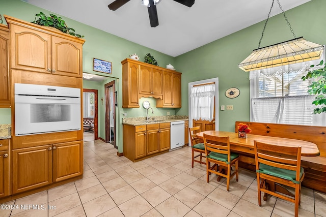 kitchen with light tile patterned flooring, ceiling fan, sink, and white appliances