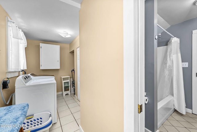 laundry area with independent washer and dryer and light tile patterned floors