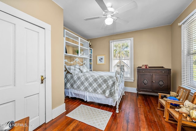 bedroom with multiple windows, dark wood-type flooring, and ceiling fan