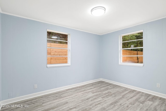 unfurnished room with crown molding and light wood-type flooring