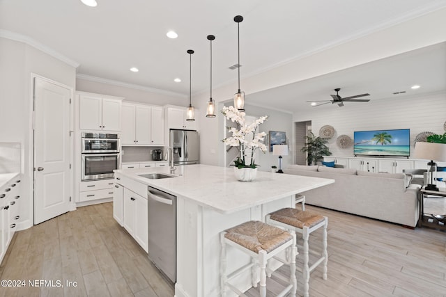 kitchen featuring white cabinets, a kitchen island with sink, stainless steel appliances, ceiling fan, and sink