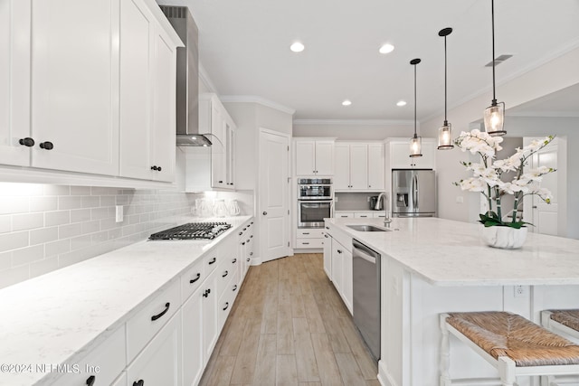 kitchen with stainless steel appliances, sink, white cabinets, a kitchen breakfast bar, and an island with sink