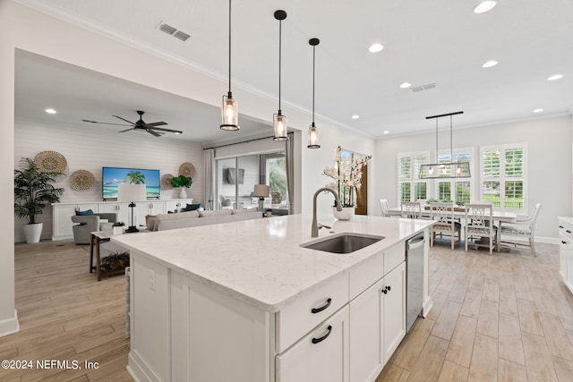 kitchen featuring dishwasher, a kitchen island with sink, light stone counters, sink, and white cabinetry