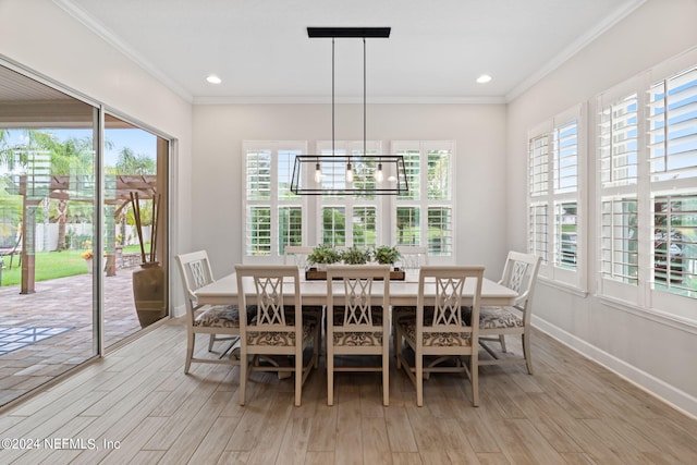 dining room featuring ornamental molding, light hardwood / wood-style flooring, and plenty of natural light