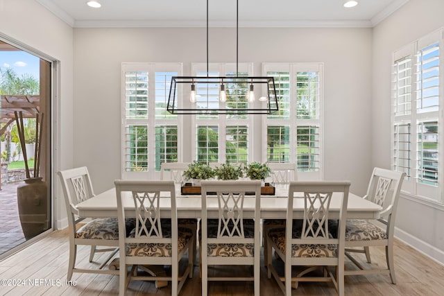 dining room featuring ornamental molding, a wealth of natural light, and light hardwood / wood-style flooring