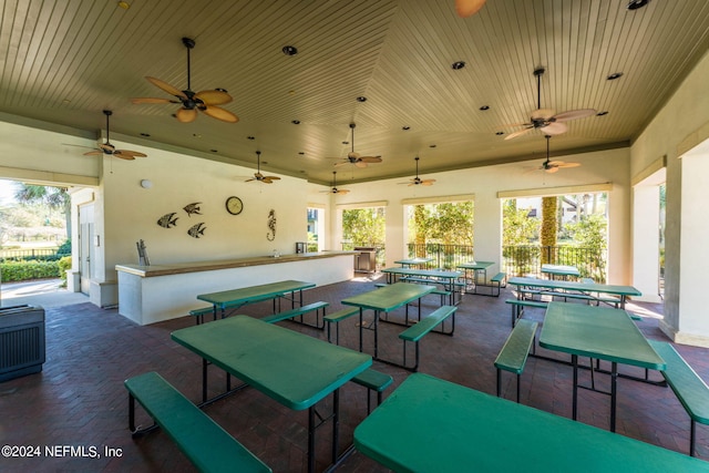 view of patio / terrace with fence, ceiling fan, and exterior bar