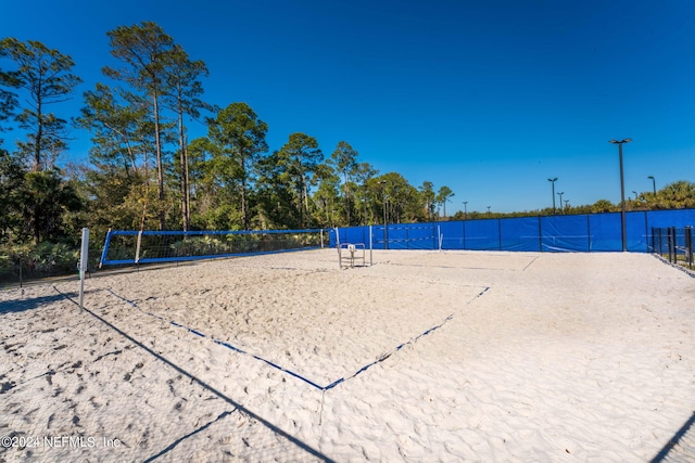 view of property's community with volleyball court and fence