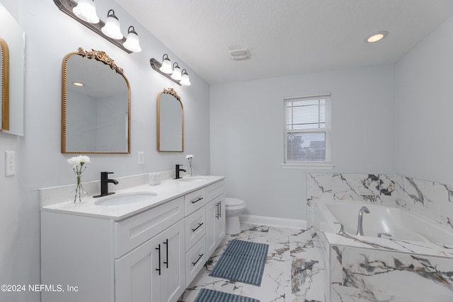 bathroom featuring vanity, a relaxing tiled tub, toilet, and a textured ceiling