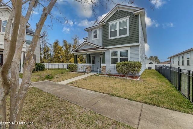 view of front facade featuring covered porch, a front lawn, and fence