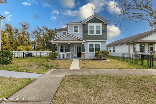 view of front facade featuring covered porch, a front yard, and fence