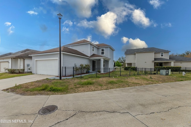 view of front of property featuring a fenced front yard, driveway, and an attached garage