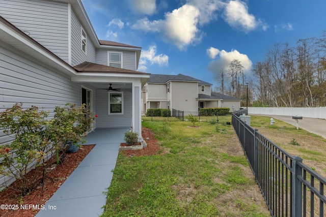 view of yard with a fenced backyard and ceiling fan