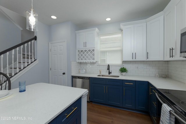 kitchen with stainless steel appliances, blue cabinetry, a sink, and light countertops