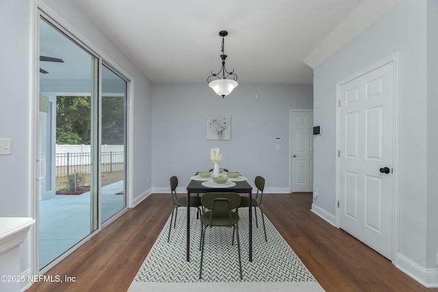 dining area with baseboards and dark wood-style flooring