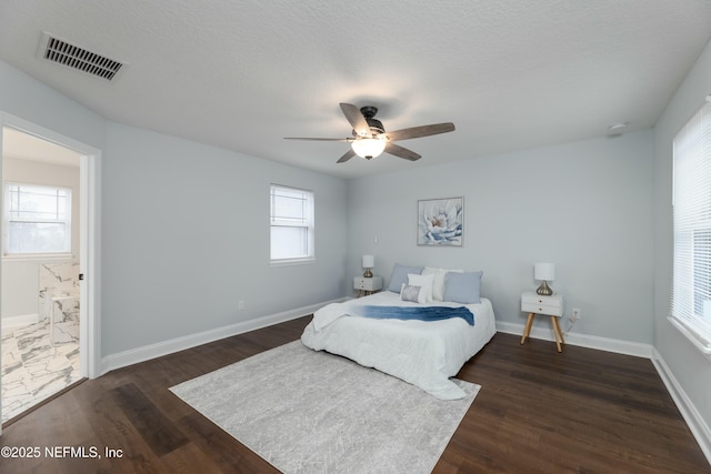 bedroom with baseboards, visible vents, dark wood-style floors, ceiling fan, and a textured ceiling