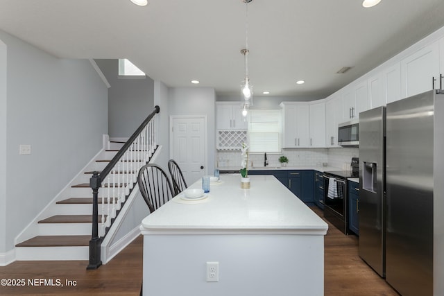 kitchen with stainless steel appliances, decorative backsplash, dark wood-type flooring, white cabinets, and a sink