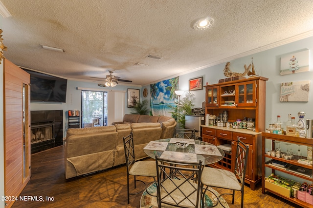 dining room featuring ornamental molding, a textured ceiling, ceiling fan, and dark hardwood / wood-style flooring