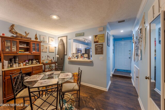 dining space featuring a textured ceiling, crown molding, and dark hardwood / wood-style flooring