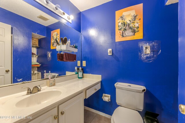 bathroom with vanity, tile patterned flooring, toilet, and a textured ceiling