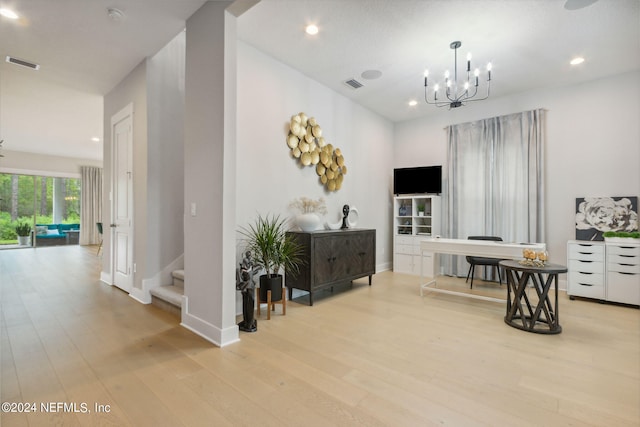 hall featuring light hardwood / wood-style flooring and a chandelier